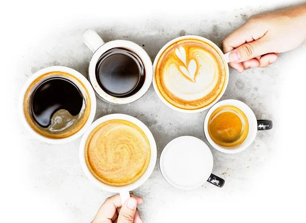 Assorted cups of black coffee, espresso and latte viewed from above.