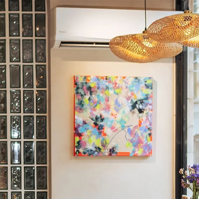 Colorful abstract artwork beneath woven pendant lights inside the café.