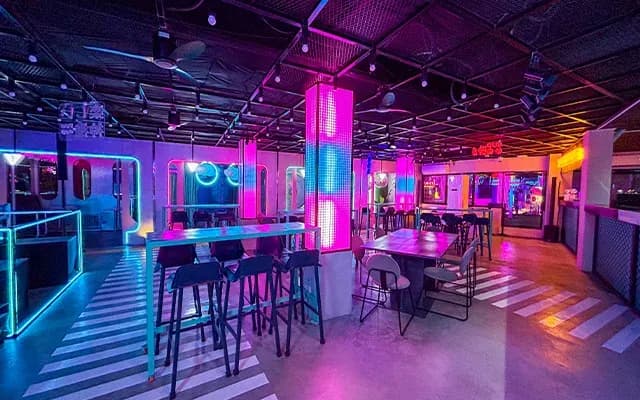 Colorful indoor tables and cabana seating at The Fun Roof