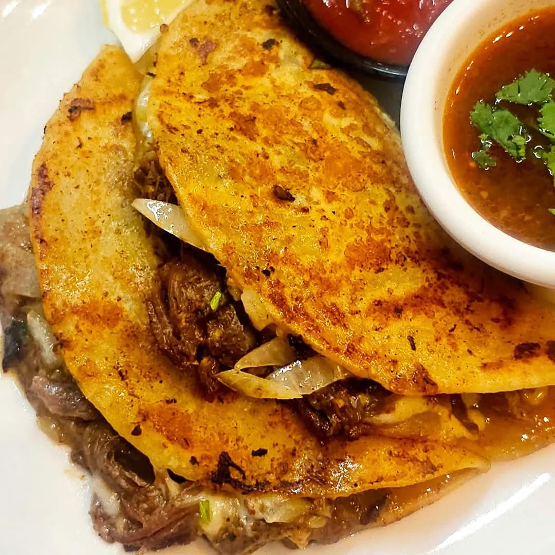 Browned quesabirria tacos filled with shredded beef and cheese
