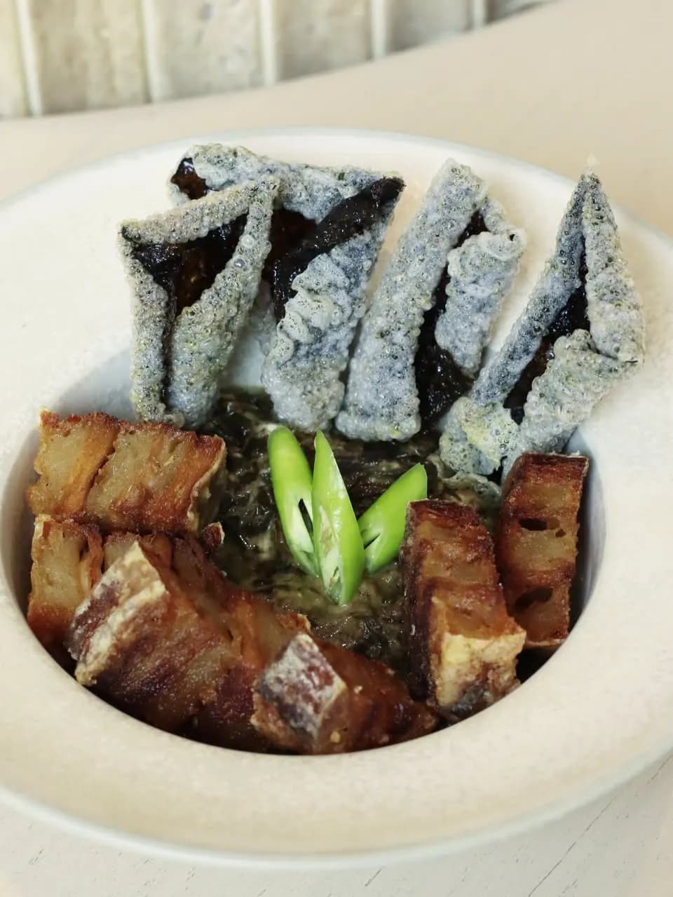 Laing with plant-based bagnet, crisp pieces and green chili garnish